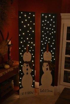 two snowmen standing next to each other with lights on them