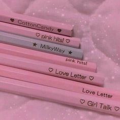 four pink pencils with writing on them are laying next to each other in the shape of hearts