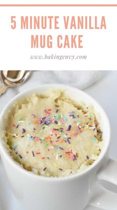 a white mug filled with cake and sprinkles on top of a table