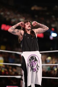 a man standing on top of a wrestling ring holding his hands up to his head