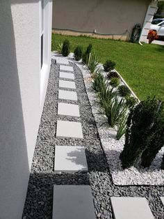 a walkway made out of stones and gravel next to a building