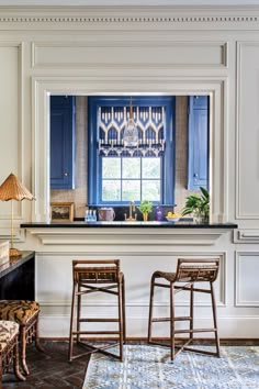 two wooden stools sit in front of a bar with an ornate window behind it