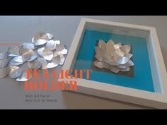 a white box with silver foil flowers in it and the words tea light holder below