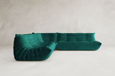 a green couch sitting on top of a white floor