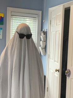 a ghost is standing in front of a door with sunglasses on it's head