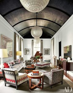 a living room filled with furniture and a chandelier hanging from the ceiling above