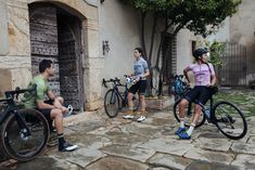 three people standing around with their bikes