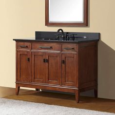 a bathroom vanity with a mirror above it and a rug on the floor next to it