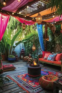 an outdoor area with lots of colorful decorations and lights hanging from the ceiling, surrounded by greenery