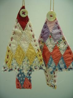 two handmade quilts hanging from strings with buttons on the top and bottom of them