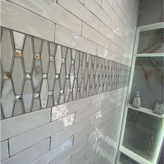 a bathroom with white tiles and glass shelves