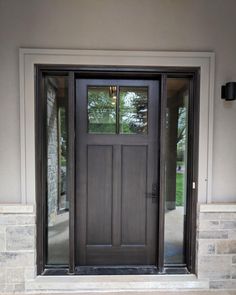 the front door to a house with glass and wood doors, is shown in black