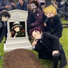 some people are posing for a photo in front of a grave with faces painted on it