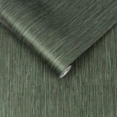 a close up view of a green wallpaper with vertical lines on the fabric,