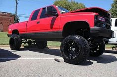 a red pick up truck parked in a parking lot