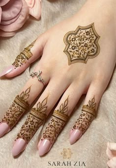 a woman's hand with henna tattoos on it