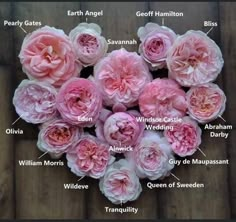 a bunch of pink flowers sitting on top of a wooden table