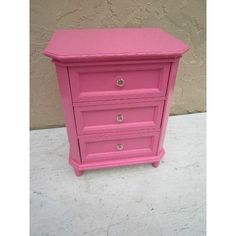 a pink dresser sitting on top of a cement floor