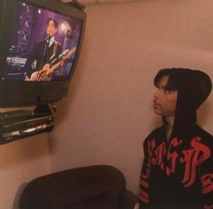 a young man sitting in front of a tv