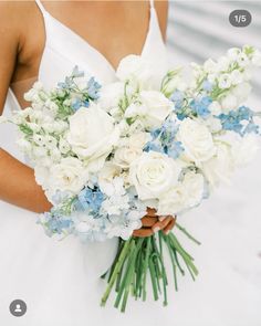 a bride holding a bouquet of white and blue flowers