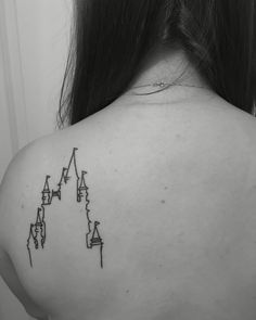 the back of a woman's shoulder with an arrow tattoo on her left side