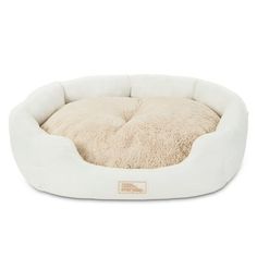 a white dog bed with a fluffy pillow on it's back and the bottom half is