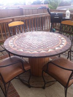 an outdoor table with four chairs around it