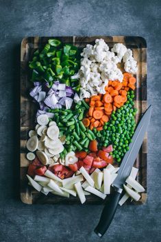 a cutting board topped with vegetables next to a knife