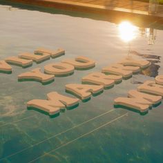 there are letters that spell out the word pool written in water with sun shining behind them