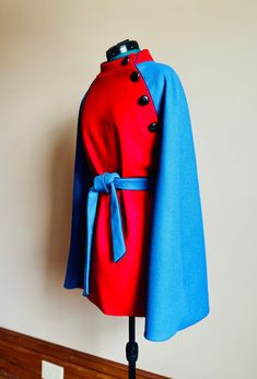 One of a kind belted cape featuring Pendleton wool in a bright scarlet and blue with piping detail. Cape fully lined and has been hand finished. Accent belt is not attached.  This coat is a loose fit best suited for a size 2-12. Dress form is a size 6, 34B bust.  All of my work is one of a kind as I mainly work with repurposed vintage textiles and do not repeat designs in the same print/pattern combination. I take great pride in my creations and am happy to honor returns should your purchase be not as expected or have fit issues. Please feel free to reach out with questions regarding fit and measurements to ensure proper fit. Multicolor Winter Cape Poncho, Vintage Fitted Cape Outerwear, One-size Wool Winter Cape, Red One-size Poncho Cape, Vintage Wool Cape Outerwear, Belted Cape, Patchwork Crop Top, Pendleton Wool, Dress Form