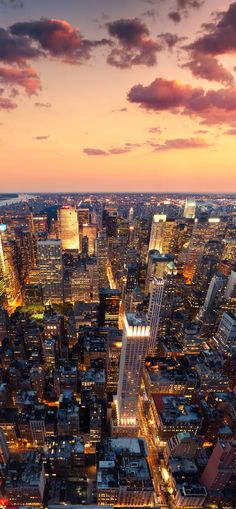 an aerial view of the city at night with lights on and skyscrapers lit up