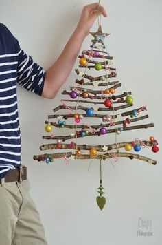 a man is holding up a christmas tree decoration