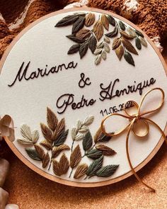 a wedding gift for the bride and groom is embroidered onto a wooden circle with leaves