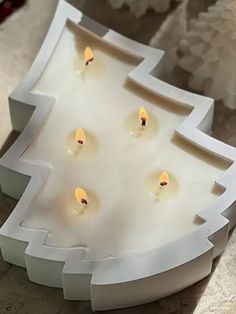 some candles are lit in a white candle holder