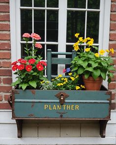 an old planter with flowers in it on the side of a building