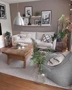 a living room filled with lots of furniture and pictures hanging on the wall above it