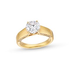 a yellow gold engagement ring with a round diamond in the center and pave set shoulders