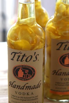 two bottles filled with yellow liquid sitting on top of a table