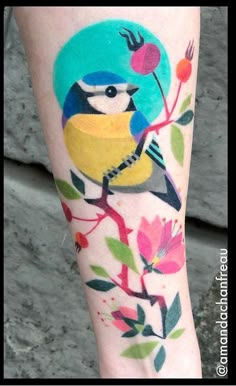 a colorful bird on a branch with leaves and flowers painted on it's leg