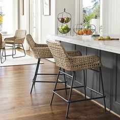 two wicker bar stools sit at the end of a kitchen island