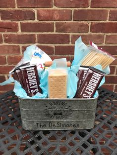 a metal bucket filled with chocolate and marshmallows next to a brick wall