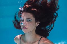 a woman with her hair in the air under water