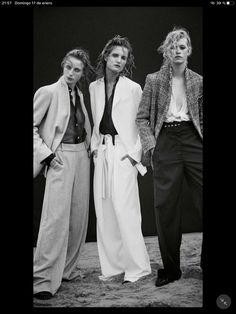 three women standing next to each other in black and white