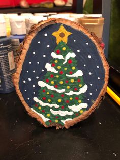 a painted christmas tree on a piece of wood