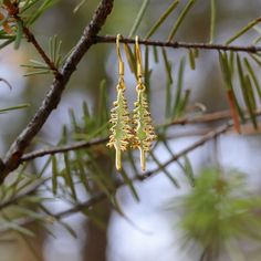 Branch out with these playful Pine Tree Earrings. These gold plated beauties are hypo allergenic and perfect for sensitive ears. Standing at 1", these quirky earrings are the perfect way to add a touch of nature to your jewelry collection. A Montana Scene Original Design. All designs are property of The Montana Scene. All rights reserved. All of The Montana Scene apparel is designed and printed locally in Montana. Come visit our storefront locations! Bigfork * Whitefish * Missoula * Kalispell * Nickel-free Nature-inspired Earrings As Gift, Nickel-free Nature-inspired Earrings For Gift, Nature-inspired Hypoallergenic Dangle Earrings, Nature-inspired Dangle Hoop Earrings, Nature-inspired Dangle Hoop Earrings As Gift, Nature-inspired Dangle Hoop Earrings For Gift, Whimsical Nickel-free Earrings For Gift, Whimsical Gold Hoop Earrings Gift, Whimsical Gold Hoop Earrings As Gift