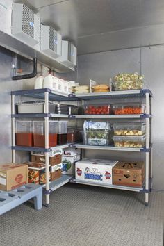 an industrial kitchen filled with lots of food and containers on shelving units in front of the stove