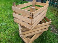 several wooden crates stacked on top of each other in the middle of some green grass