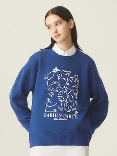 a woman wearing a blue garden party sweater