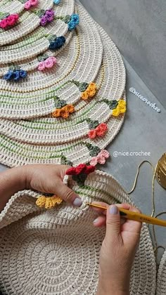 a woman is working with crochet on a rug