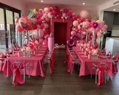 a room filled with tables covered in pink and white balloons